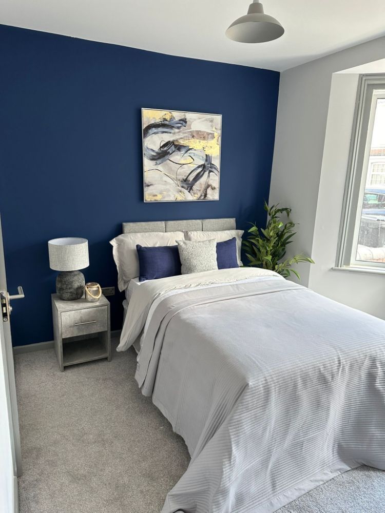 Clean, fresh bedroom with installed bed by Construction Edge